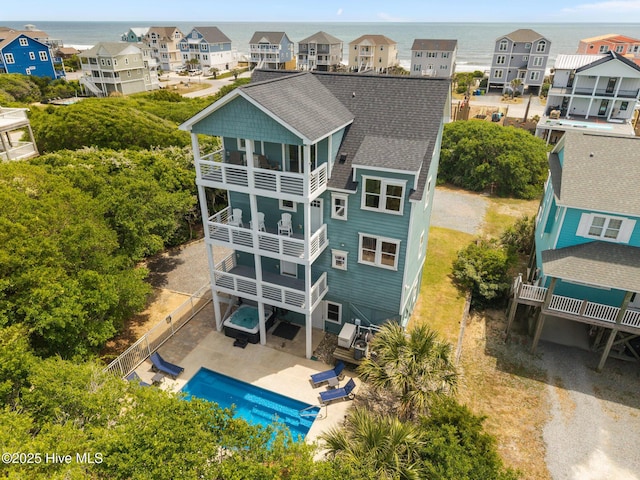 aerial view of residential area with a pool and a nearby body of water