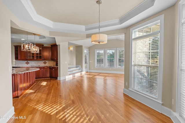 1109 Rollingwood Ct, Leland, NC 28451 - unfurnished dining area featuring a chandelier, light wood finished floors, ornamental molding, a tray ceiling, and stairway