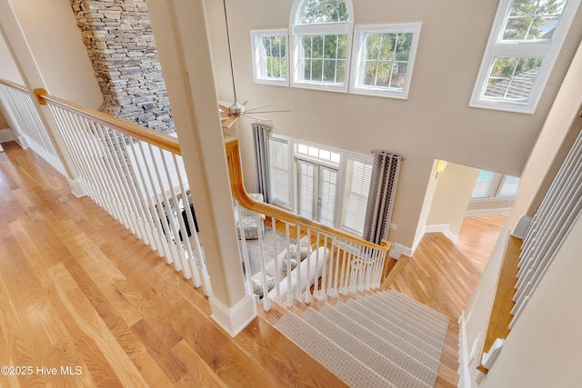 1109 Rollingwood Ct, Leland, NC 28451 - staircase featuring wood finished floors, plenty of natural light, a ceiling fan, and a towering ceiling