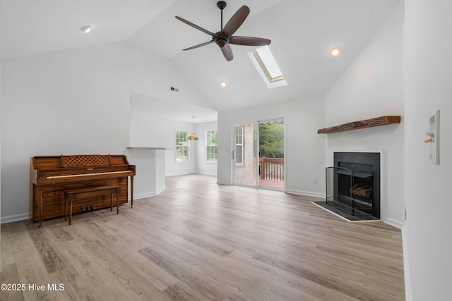 417 Settlers Ln, Kure Beach, NC 28449 - living area with a ceiling fan, a skylight, high vaulted ceiling, a fireplace with flush hearth, and wood finished floors