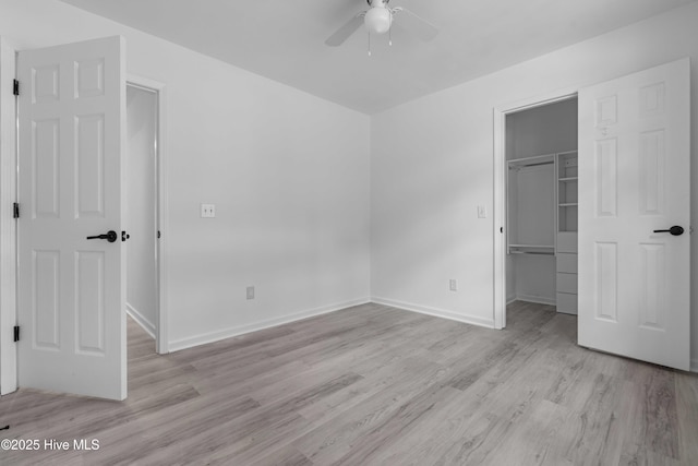 417 Settlers Ln, Kure Beach, NC 28449 - unfurnished bedroom with a spacious closet, light wood-style floors, a closet, baseboards, and ceiling fan