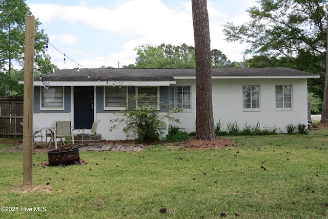 view of front of house featuring stucco siding, an outdoor fire pit, and roof with shingles