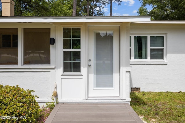 entrance to property featuring stucco siding