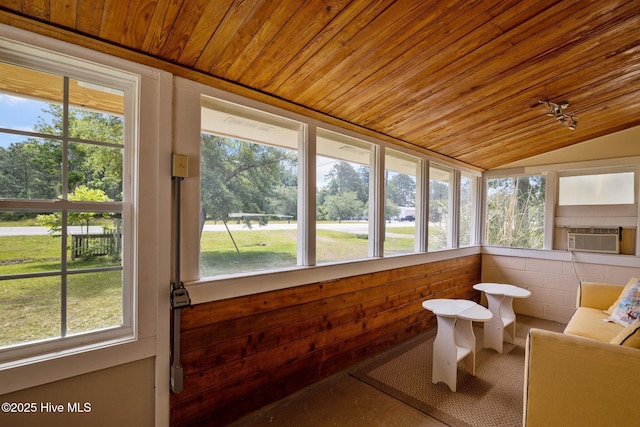 sunroom featuring wood ceiling, cooling unit, plenty of natural light, vaulted ceiling, and view of scattered trees