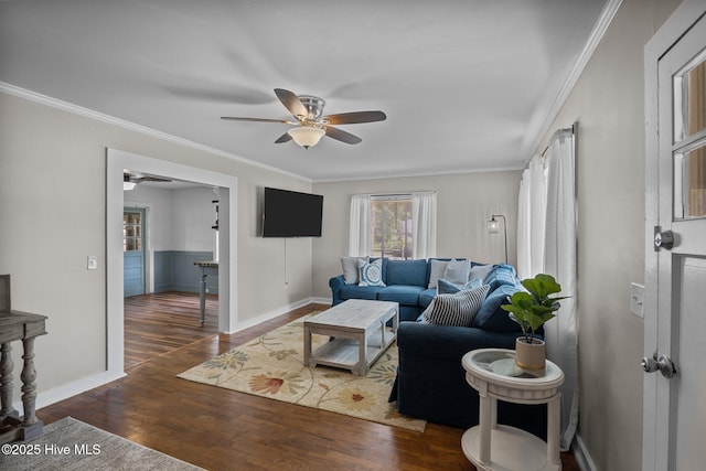living area featuring ceiling fan, wood finished floors, ornamental molding, and baseboards