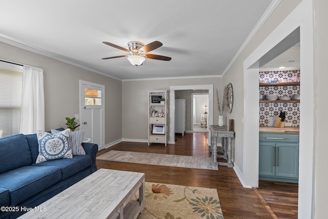 living area with dark wood-type flooring, a ceiling fan, baseboards, and crown molding