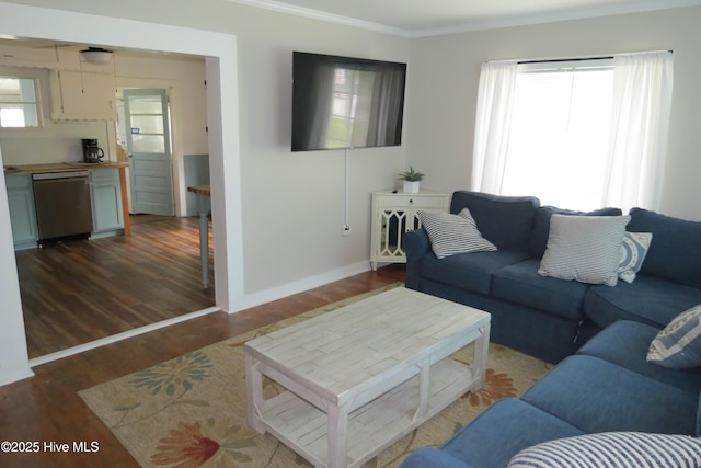 living room with crown molding, baseboards, and wood finished floors