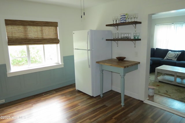 kitchen featuring freestanding refrigerator, wainscoting, dark wood finished floors, open shelves, and butcher block counters