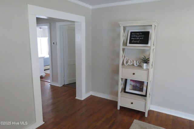 hallway featuring ornamental molding, wood finished floors, and baseboards