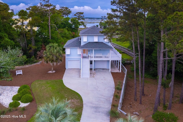 9808 Clarendon Dr, Emerald Isle, NC 28594 - coastal home with stairway, roof with shingles, covered porch, driveway, and an attached garage