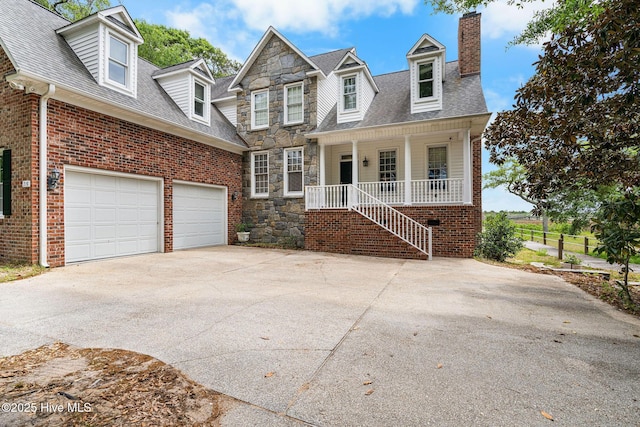 view of front of property featuring driveway, covered porch, a chimney, brick siding, and a shingled roof