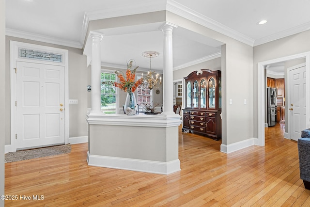 foyer featuring ornate columns, light wood-style floors, baseboards, ornamental molding, and recessed lighting