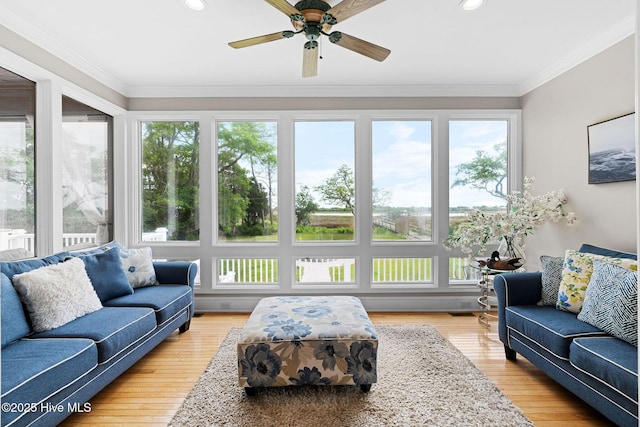 sunroom / solarium featuring healthy amount of natural light, a wooden deck, wood finished floors, crown molding, and recessed lighting