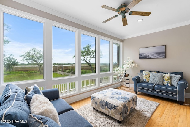 living area featuring a ceiling fan, recessed lighting, crown molding, light wood-style floors, and baseboards