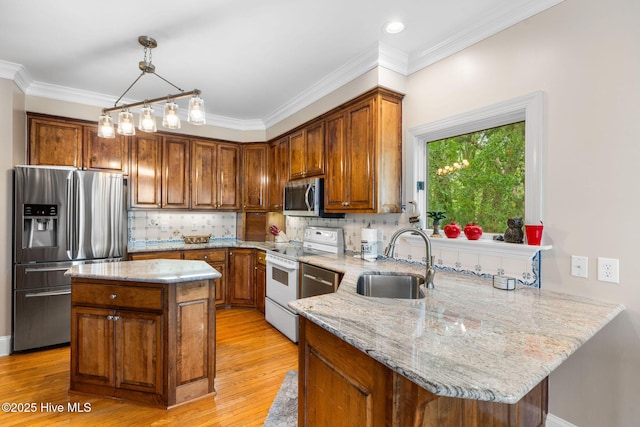 kitchen with stainless steel appliances, a sink, brown cabinets, light stone countertops, and ornamental molding