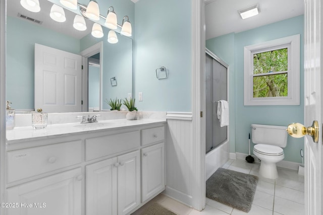 full bathroom with toilet, vanity, tile patterned flooring, shower / bath combination with glass door, and baseboards