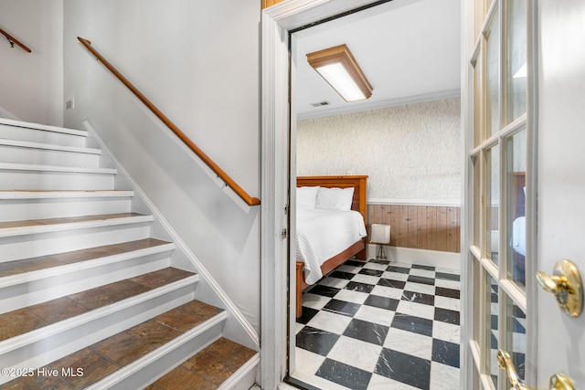 stairs featuring a wainscoted wall, tile patterned floors, and wooden walls