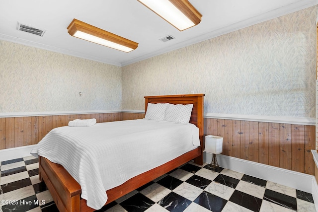 bedroom with tile patterned floors, wainscoting, wooden walls, and crown molding