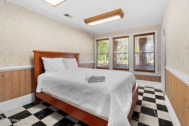 bedroom featuring tile patterned floors, ornamental molding, wood walls, a wainscoted wall, and baseboards