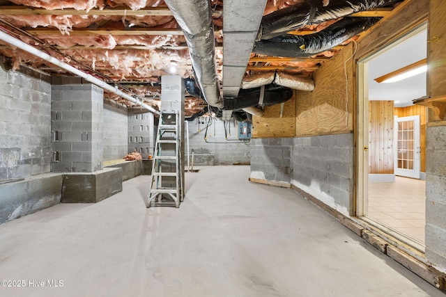 unfinished below grade area featuring concrete block wall and electric panel