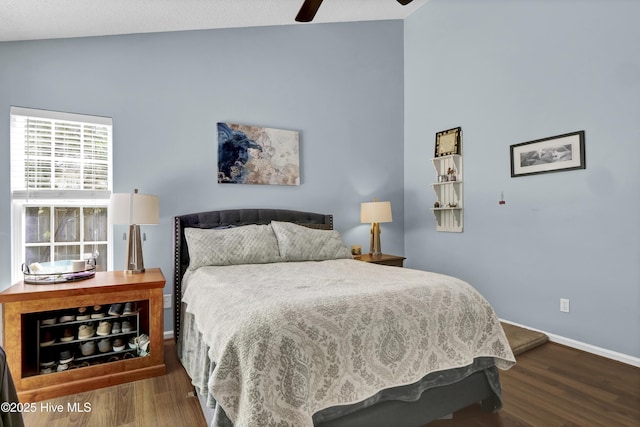 bedroom featuring wood finished floors, baseboards, lofted ceiling, and a ceiling fan