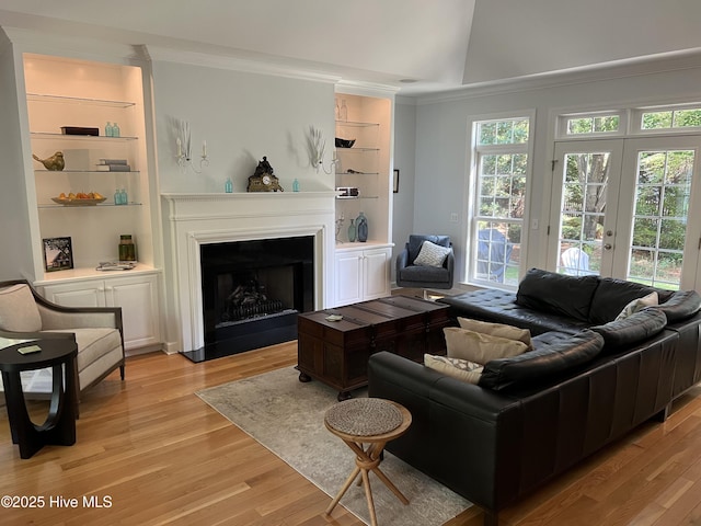 50 Short Rd, Pinehurst, NC 28374 - living room with light wood-style floors, lofted ceiling, a fireplace with flush hearth, crown molding, and built in shelves
