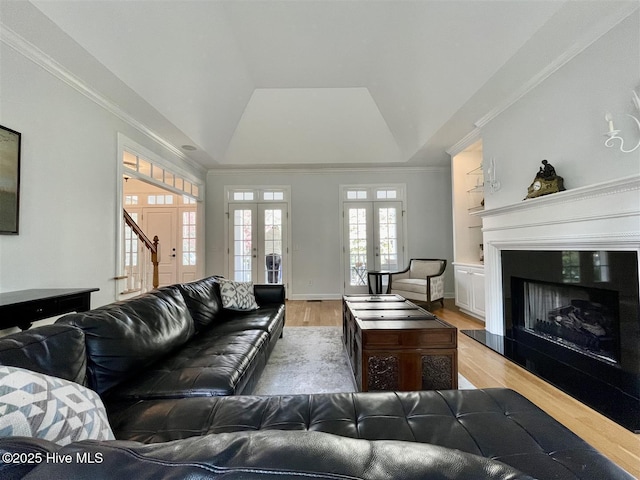 50 Short Rd, Pinehurst, NC 28374 - living area with french doors, light wood-style flooring, a tray ceiling, a fireplace with raised hearth, and crown molding