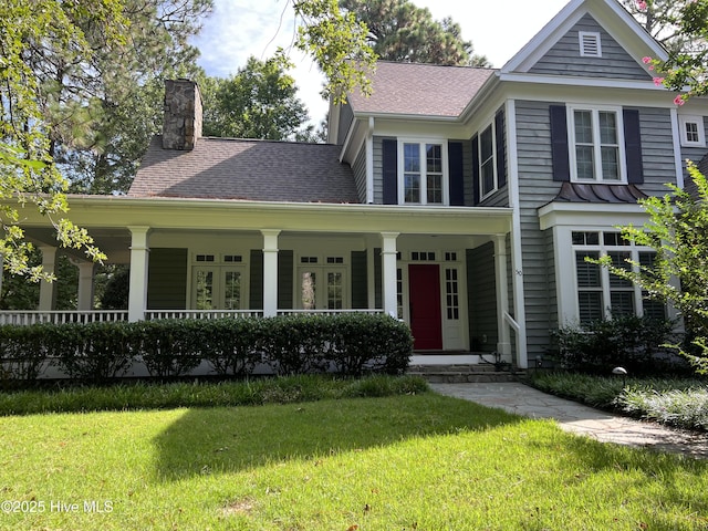 50 Short Rd, Pinehurst, NC 28374 - view of front of property with a front lawn, a porch, a chimney, and roof with shingles