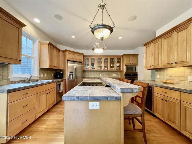 50 Short Rd, Pinehurst, NC 28374 - kitchen featuring stainless steel appliances, a kitchen bar, a center island, light wood finished floors, and tasteful backsplash