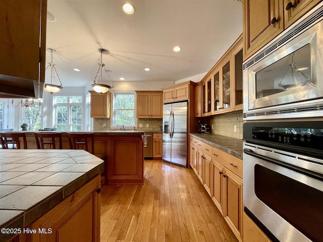 50 Short Rd, Pinehurst, NC 28374 - kitchen featuring stainless steel appliances, backsplash, recessed lighting, glass insert cabinets, and light wood-style floors