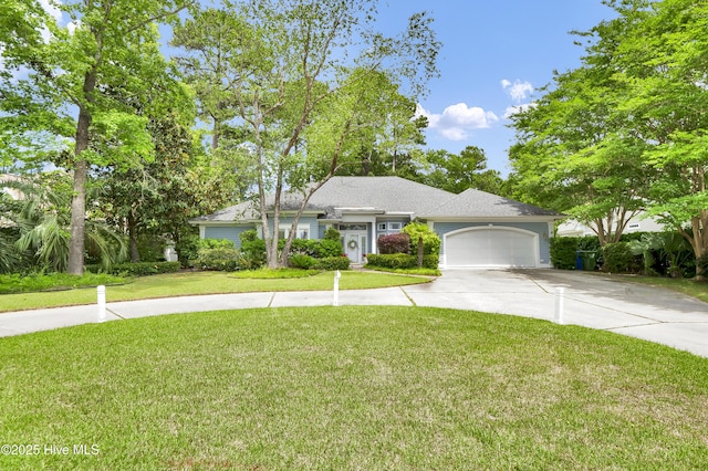 view of front of property with concrete driveway, a garage, and a front lawn