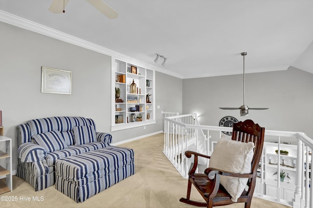 sitting room with a ceiling fan, an upstairs landing, carpet flooring, built in shelves, and vaulted ceiling