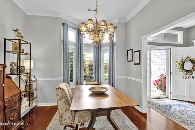 dining area featuring a chandelier, dark wood-style flooring, baseboards, and crown molding