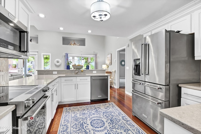 kitchen featuring stainless steel appliances, a sink, dark wood finished floors, light countertops, and recessed lighting