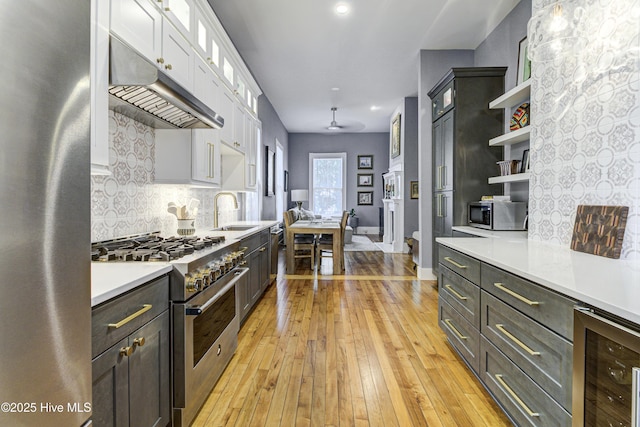 kitchen featuring stainless steel appliances, beverage cooler, under cabinet range hood, open shelves, and backsplash