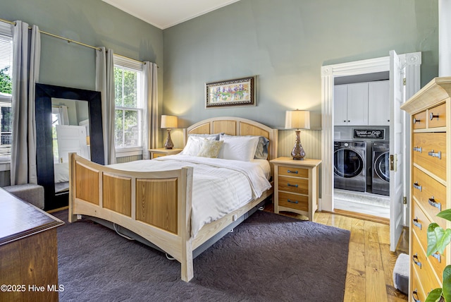 bedroom featuring independent washer and dryer and hardwood / wood-style floors