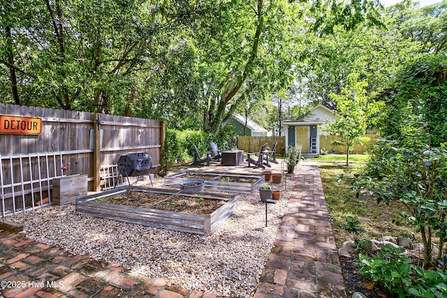 fenced backyard featuring a garden and an outdoor structure