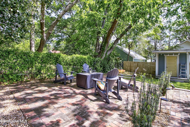 view of patio with an outdoor fire pit and fence