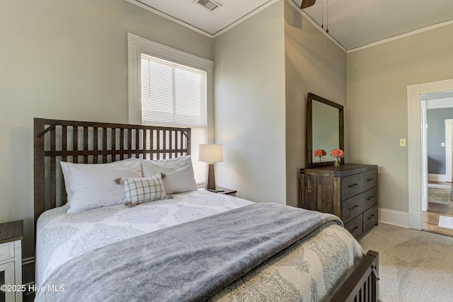 carpeted bedroom with ornamental molding and baseboards
