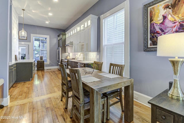 dining area with light wood-style floors, baseboards, and recessed lighting