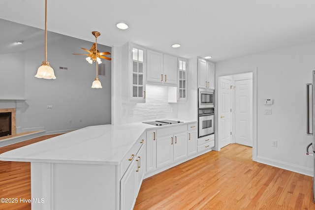 1103 Groppo Cv, Wilmington, NC 28412 - kitchen featuring stainless steel appliances, light wood-style floors, a ceiling fan, backsplash, and a peninsula