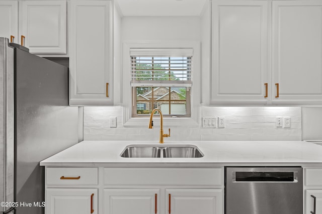 1103 Groppo Cv, Wilmington, NC 28412 - kitchen with appliances with stainless steel finishes, a sink, backsplash, and white cabinetry