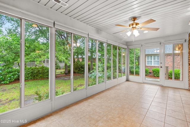 unfurnished sunroom with ceiling fan and healthy amount of natural light