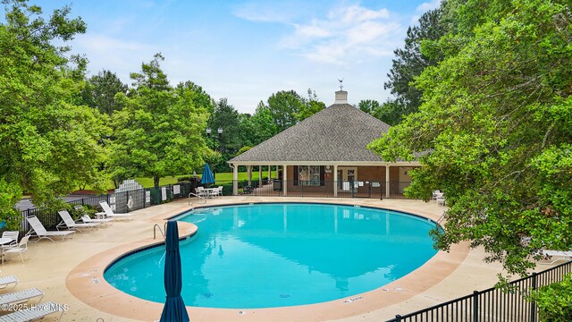 1103 Groppo Cv, Wilmington, NC 28412 - community pool featuring a patio area and view of scattered trees