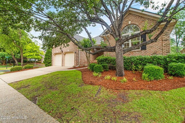 1103 Groppo Cv, Wilmington, NC 28412 - view of front of house featuring brick siding, concrete driveway, a front yard, and an attached garage