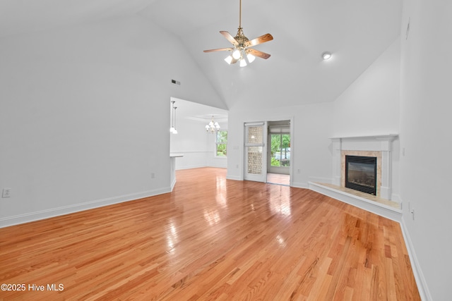 1103 Groppo Cv, Wilmington, NC 28412 - unfurnished living room featuring a high end fireplace, high vaulted ceiling, ceiling fan, a chandelier, and light wood finished floors