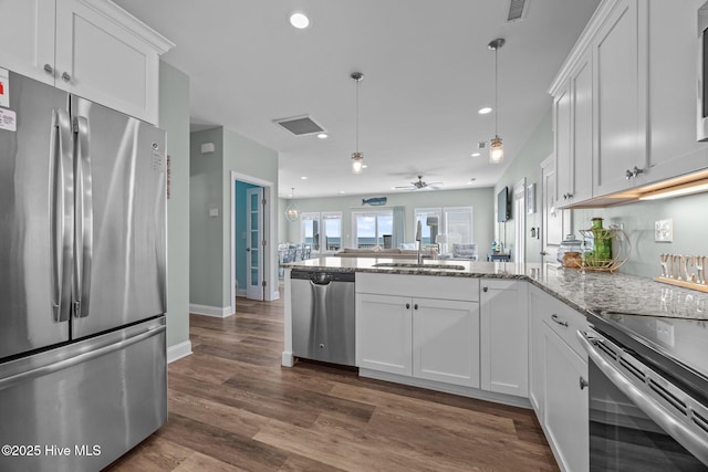 130 N Permuda Wynd Dr, North Topsail Beach, NC 28460 - kitchen featuring stainless steel appliances, a sink, a peninsula, white cabinetry, and light stone countertops