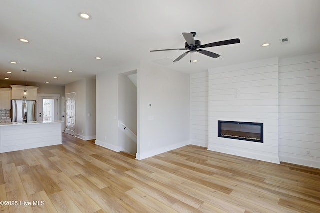 128 Sea Oaks Ct, North Topsail Beach, NC 28460 - unfurnished living room featuring recessed lighting, a fireplace, light wood finished floors, baseboards, and a ceiling fan