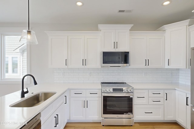 128 Sea Oaks Ct, North Topsail Beach, NC 28460 - kitchen featuring appliances with stainless steel finishes, a sink, recessed lighting, plenty of natural light, and white cabinets