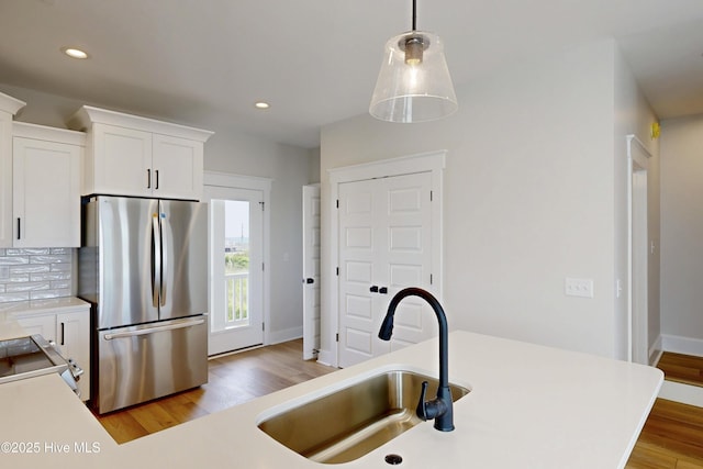 128 Sea Oaks Ct, North Topsail Beach, NC 28460 - kitchen with freestanding refrigerator, a sink, light countertops, light wood-style floors, and recessed lighting